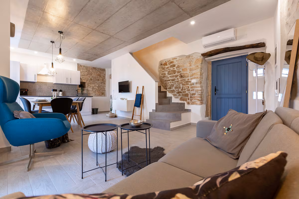 Living room with staircase and stone wall